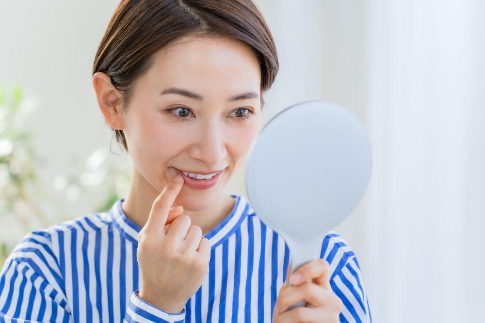 手鏡で歯をチェックする女性