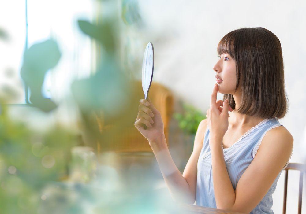 手鏡で唇を確認する女性