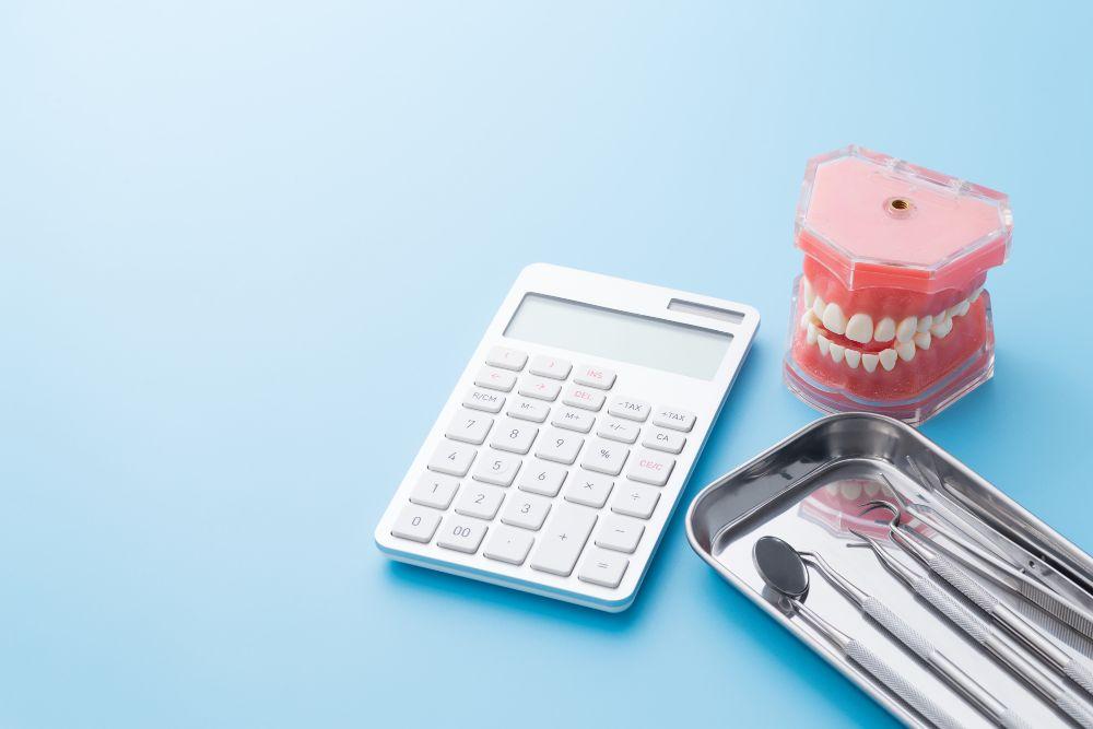 電卓と歯の模型と治療器具