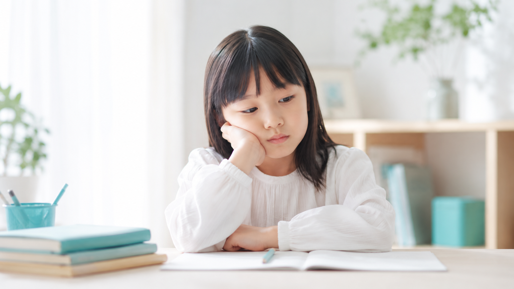 机に向かって困っている子ども